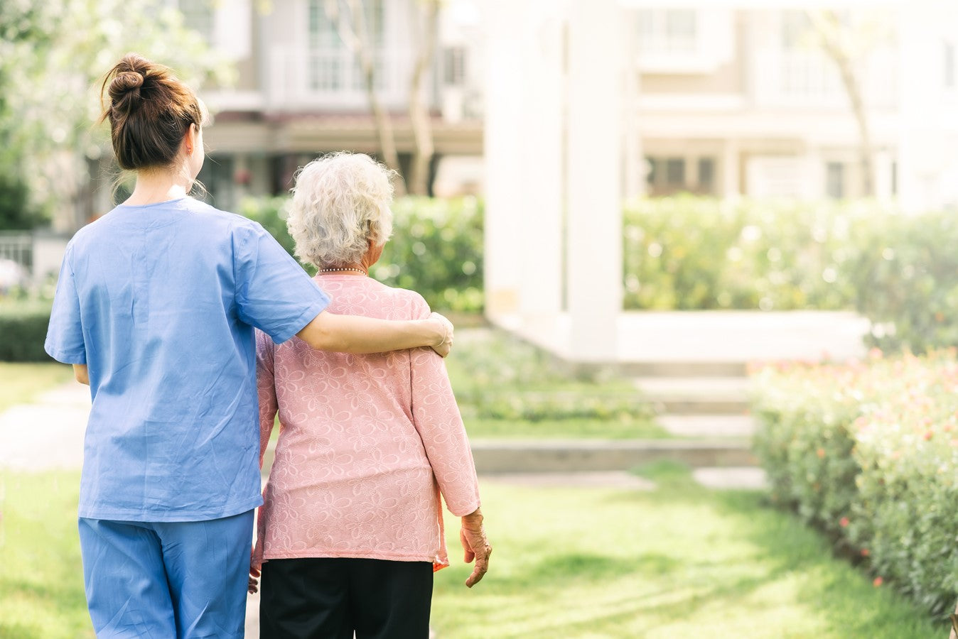 nurse holding an elderly woman from behind