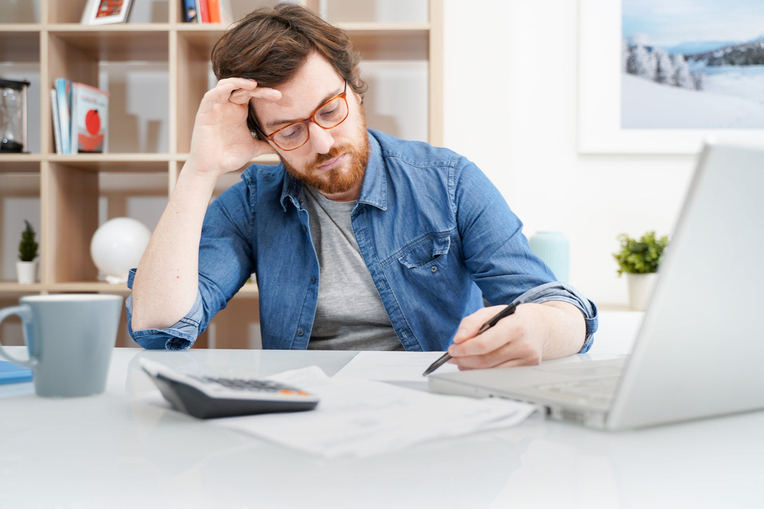 man holding a pen in front of office desk