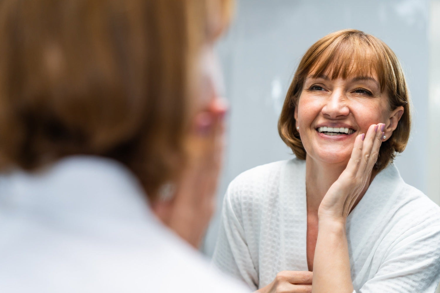 senior woman looking at mirror