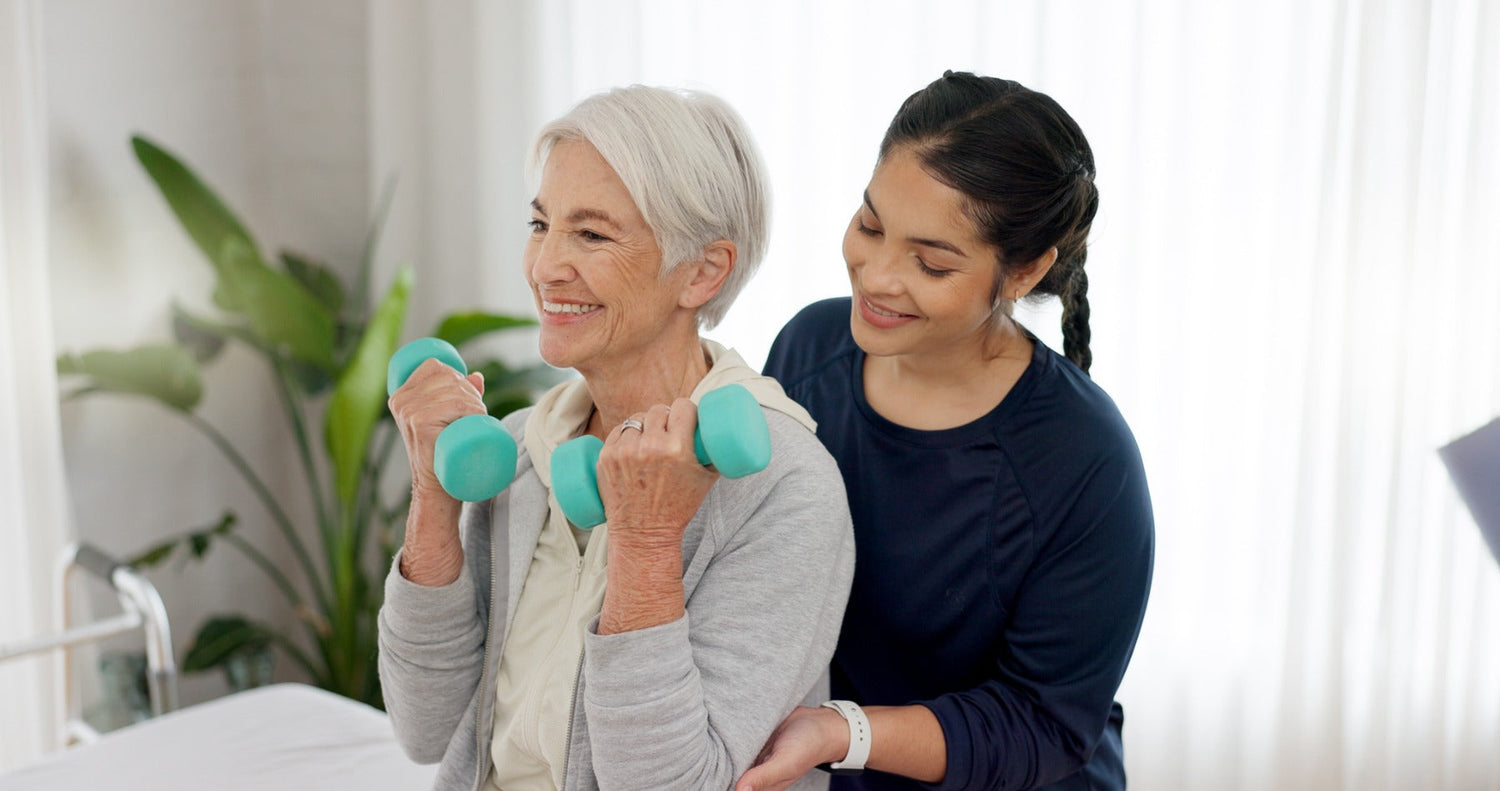elder lady lifting dumbbells with woman guiding her