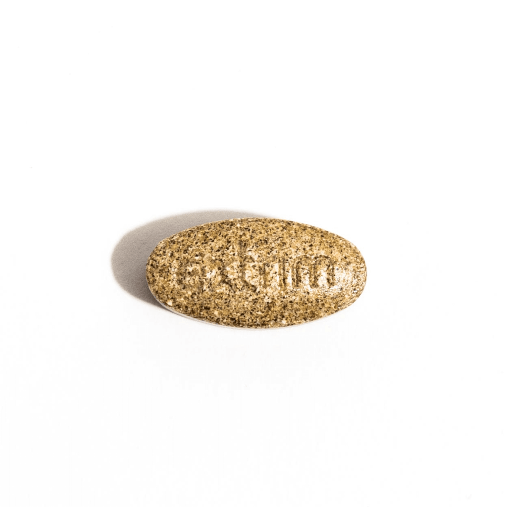 A gold-colored pill inscribed with the word 